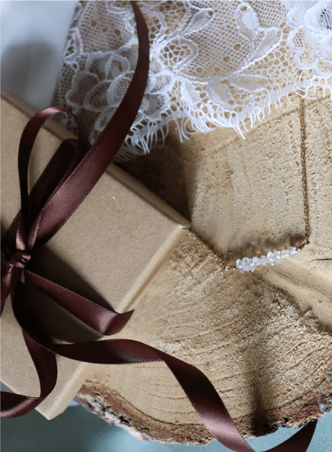 collier-lucia-diamant-herkimer-acier-inoxydable-dore-bijou-mariage.jpg Collier Lucia en acier inoxydable doré orné de perles de diamant d’Herkimer, bijou lumineux et raffiné présenté sur fond de dentelle et coffret cadeau.